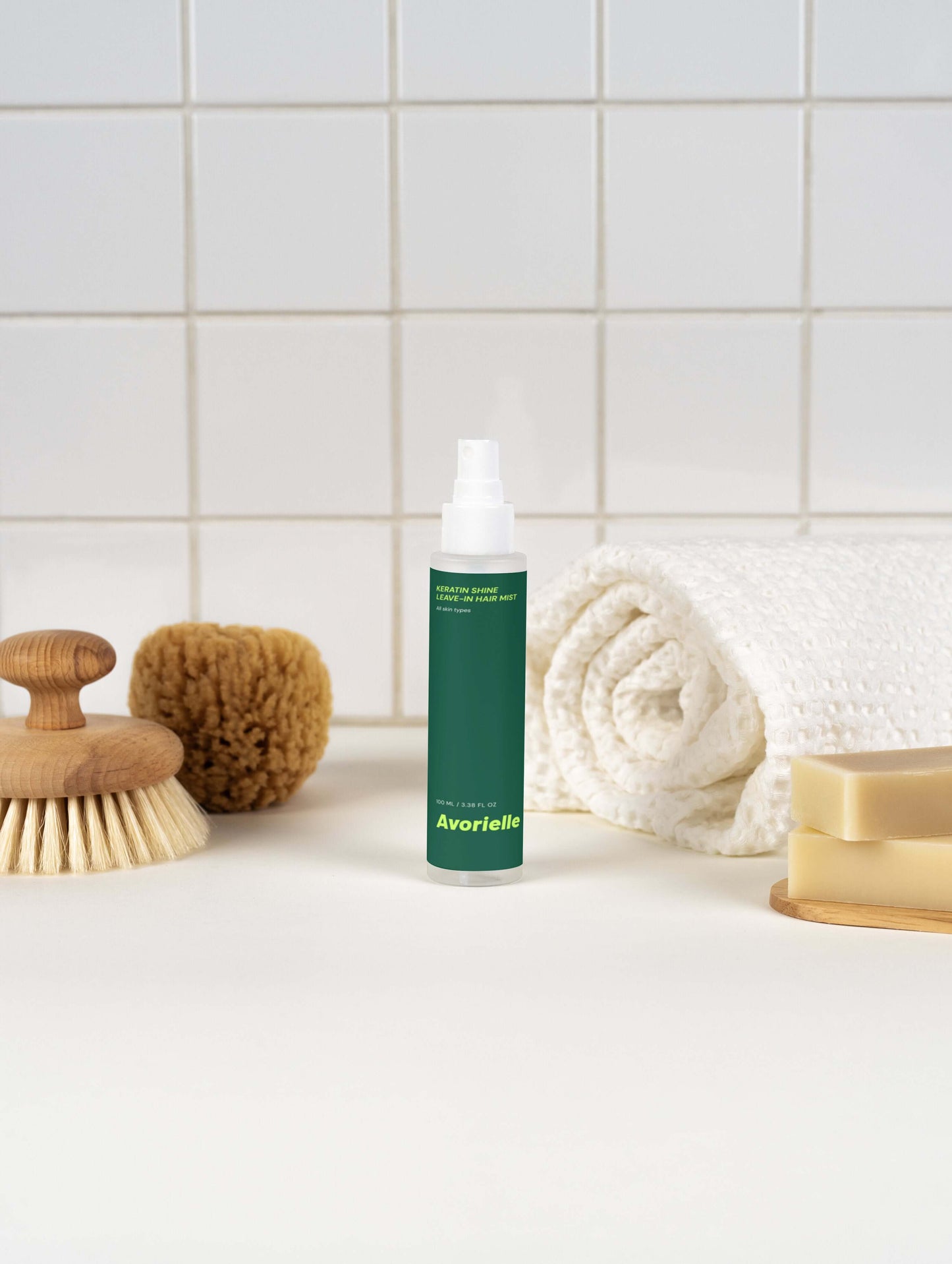 Keratin Shine Leave-In Hair Mist bottle on a minimalistic bathroom counter with a soft towel and accessories.